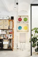 The workshop, with its concrete floor and painted brick walls, has a more industrial vibe. A Pedrera PD2 floor lamp by Barba Corsini for Gubi sits beneath artwork from Esther’s "Shinbun" collection.