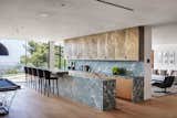 The gourmet kitchen boasts dual marble islands, custom white oak cabinetry, and high-end Gaggenau appliances.