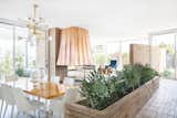 The renovation restored the built-in brick planter and exchanged the carpeting for sleek white terrazzo floors.