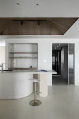 A dedicated bar counter makes entertaining easy, while the kitchen is tucked out of sight from the main room, accessible via the open doorway.