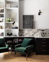 The architects set up a cozy reading nook off the kitchen, with furnishings picked by Santos. Positioned as it is beside the big windows, the spot benefits from the views outside, and enables family members to chat easily while cooking.